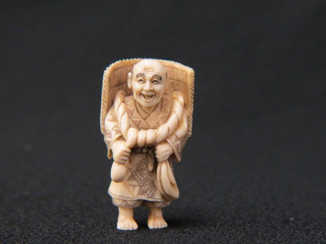 Carved Ivory Netsuke of Man,: bamboo mat on his back, 2" tall, signed, excellent.