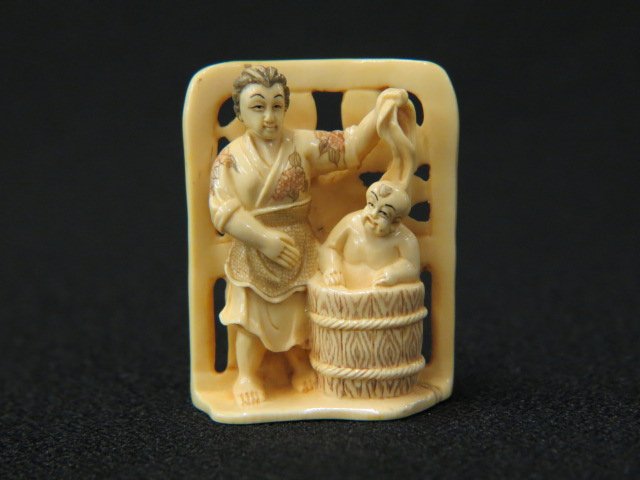 Carved Ivory Netsuke of a Mother: bathing son in front of a screen, 2" tall, signed, excellent.