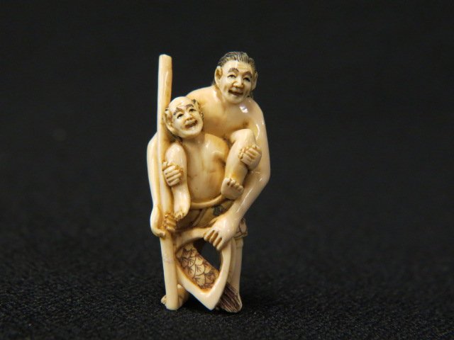Carved Ivory Netsuke of Ashinaga,: (long legs) and Tenaga (long arms) with fish, 1 3/4" tall, signed, excellent.