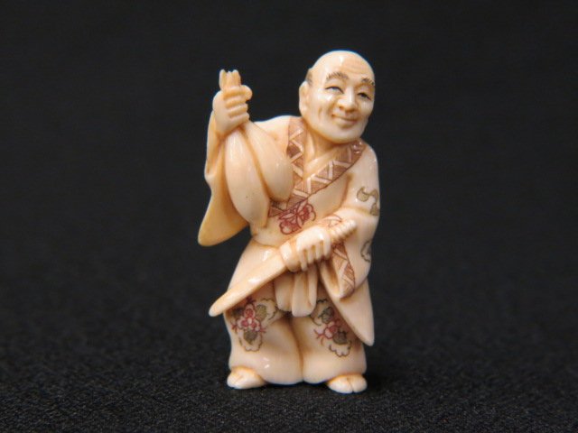 Carved Ivory Netsuke of a Man,: holding a knife and cucumbers, 2" tall, signed, excellent.