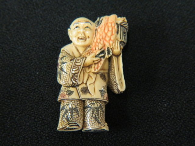 Carved Ivory Netsuke of a Man with Basket: of grapes on his shoulder, fancy polychrome, 1 7/8", signed, excellent.