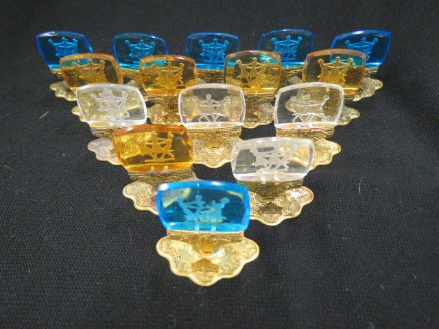 15 Intaglio Crystal Place Card Holders: with intaglio cut glass scenes of "Three Graces", dancing, each 1 1/2" tall, various colors.