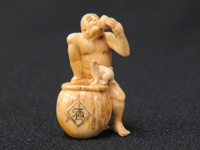 Carved Ivory Netsuke of a Man,: drinking from a sake cup, large pot ith rat on rim, 2" tall, signed, excellent.