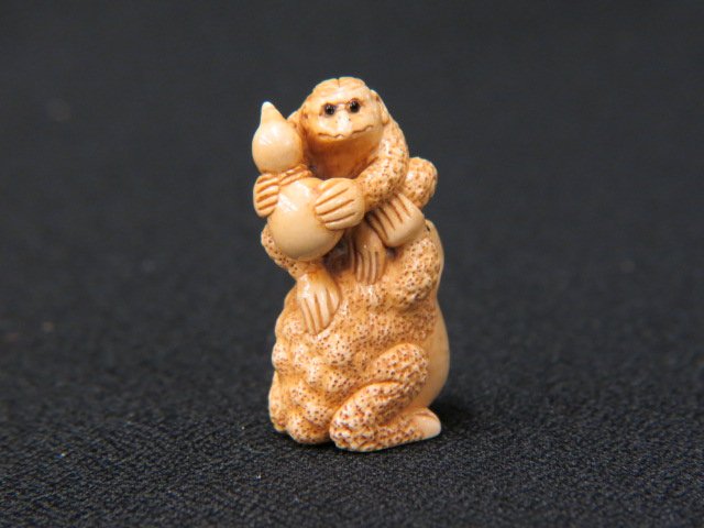 Carved Ivory Netsuke of a Frog,: with a kappa holding a gourd on his back, onyx eyes, 1 5/8" tall, signed, excellent.