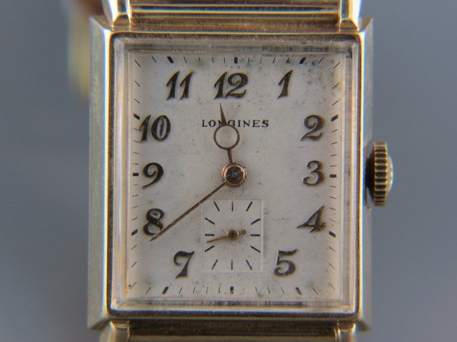 Longines 14k Man's Wristwatch,: vintage, tank style, yellow gold, leather band, currently working.In the early 1800's Swiss watchmaking was truly a cottage-industry. Watches were produced using the "etablissage" method, where indivi