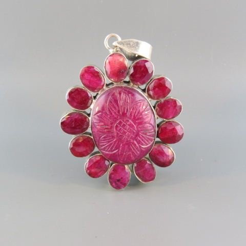 Ruby Pendant,: carved Africian cabachon gem surrounded by 13 oval gems in sterling silver, 2" x 1 3/4".