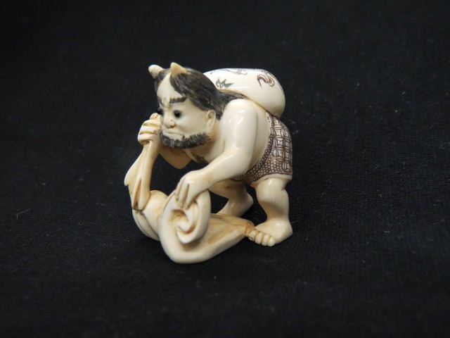 Carved Ivory Netsuke of Futen,: god of wind, holding a bag of wood and standing on storm clouds, 1 3/4", signed, excellent.