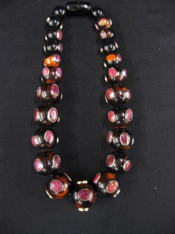 Ruby & Bakelite Necklace,: 23 graduated beads set with rich African gems bezel set in sterling silver, graduated sizes, 21" long.