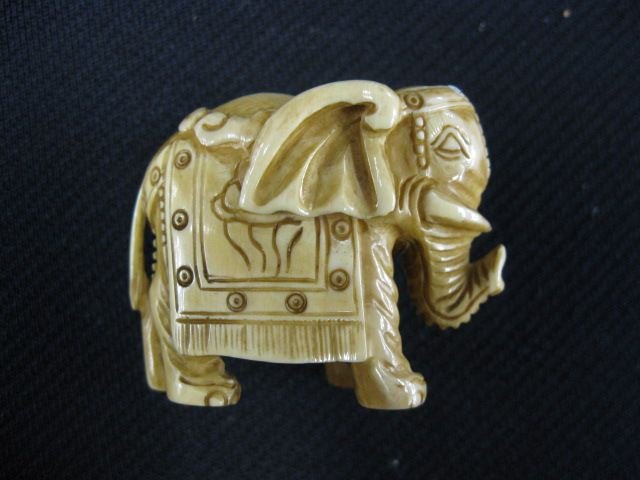 Carved Ivory Netsuke of an Elephant,: in parade dress, signed, 1 1/2, excellent."