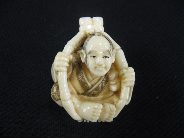 Carved Ivory Netsuke of a Man,: seated in bamboo cage, 1 3/4, excellent."