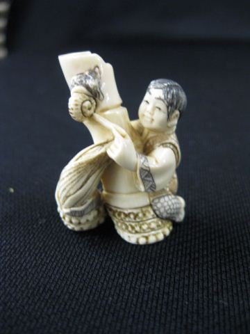 Carved Ivory Netsuke of a Seated Boy,: playing with a large piece of bamboo that has a snail on it, signed, 1 1/2, excellent."