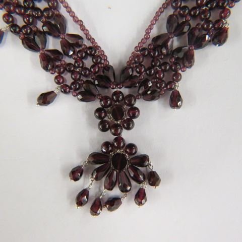 Garnet Necklace,: stunning array of deep red gems, 16" long plus tassel, together with dangling silver earrings.