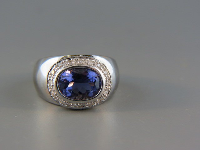 Iolite and Diamond Ring,: rich oval gem weighing 2.75 carats surrounded by 32 round diamonds totaling .33 carats, 14k white gold, with appraisal of $1,550, currently size 6.