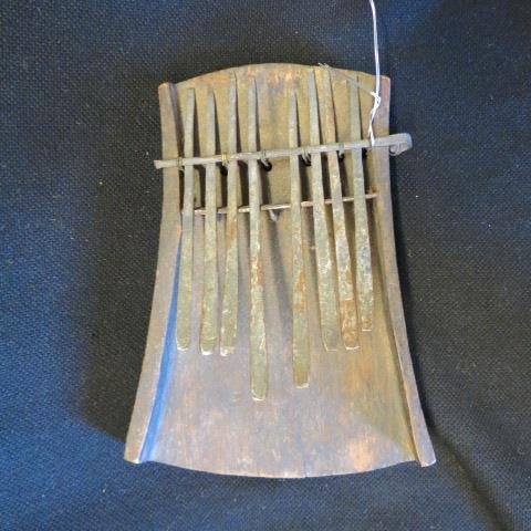 African Tribesmen Mbira Thumb Piano Musical Instrument,: carved wood and metal, 4" x 6"......The mbira or thumb piano is an African musical instrument consisting of a wooden board (often fitted with a resonator) with attached staggered metal tines, played b