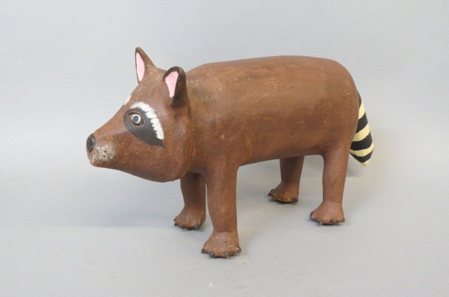 David Alvarez Folk Art Raccoon Figurine,: carved wood and painted, 10" tall, 19" long, signed....ALVAREZ, DAVID(1953–)discovered his talent as an animal woodcarver under the tutelage of Felipe Archuleta, the acknowledged master of the form.