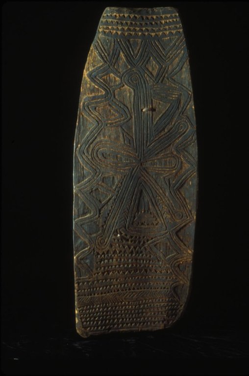 PNG War Shield from the LaCasse Collection: #19 Yassip War Shield 58" Tall from PNG East Sepic Area.. Made of wood with an intricate design that adorns the unpainted piece.