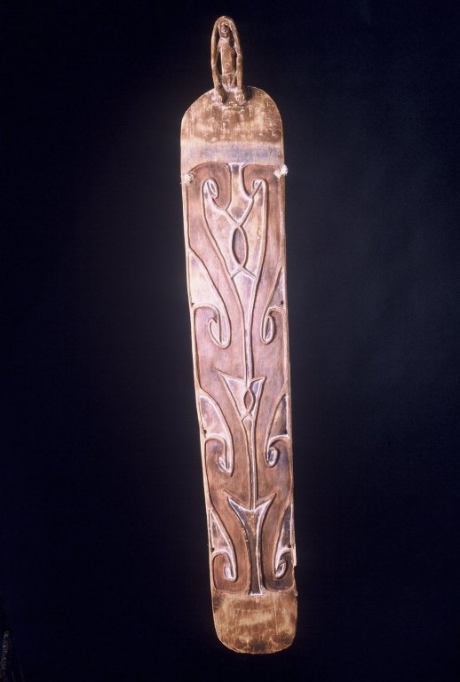 Papua New Guinea War Shield: #164 War shield 74" High with ancestral spirit on top. Color has faded. Origin:Asmat. Missing small piece on lower right side.