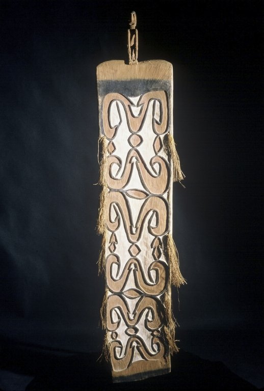 Papua New Guinea Asmat Shield: #181 71.5" high, shield designed in red on white background with one horizontal black band at top and bottom. Figure on top is a little loose.