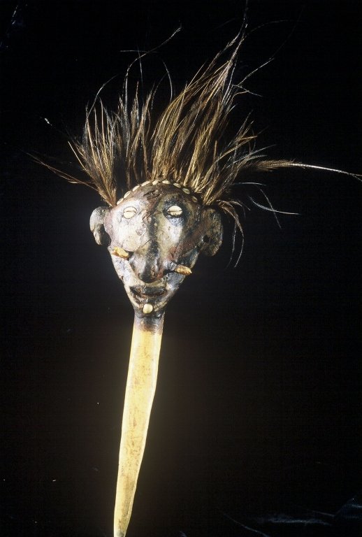 Papua New Guinea Cassowary Dagger: #325 17" high, cassowary bone dagger with human face at top decorated with shells and cassowary feathers.