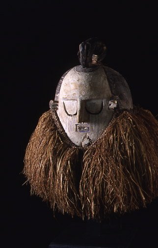 African Helmet Mask: #234 19.5" mask painted white and blue, with raffia skirt underneath face. Suku Tribe, Zaire.