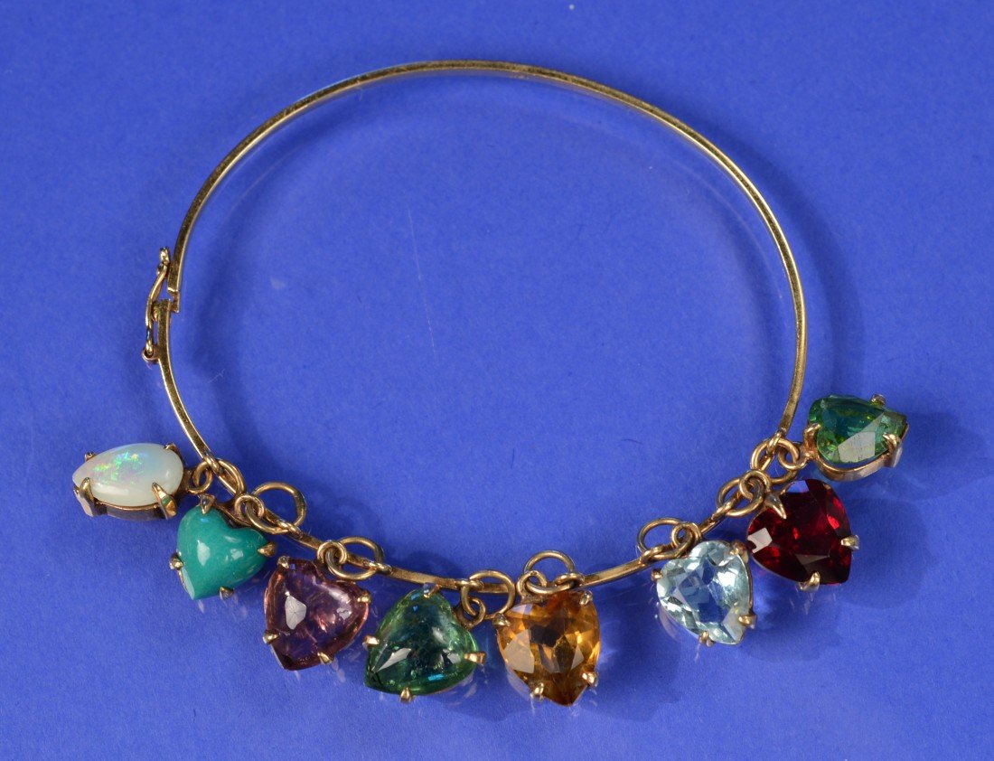 14K YELLOW GOLD AND COLORED STONE BANGLE BRACELET: 14K YELLOW GOLD AND COLORED STONE BANGLE BRACELET featuring eight heart-shaped colored stones, including: tourmaline, ruby, aquamarine, topaz, emerald, amethyst, turquoise, and opal