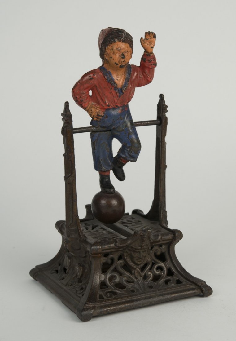 AMERICAN PAINTED AND CAST IRON MECHANICAL BOY ON: AMERICAN PAINTED AND CAST IRON MECHANICAL "BOY ON TRAPEZE" BANK, J. Barton Smith Co., Philadelphia; height: 9 1/2 in.