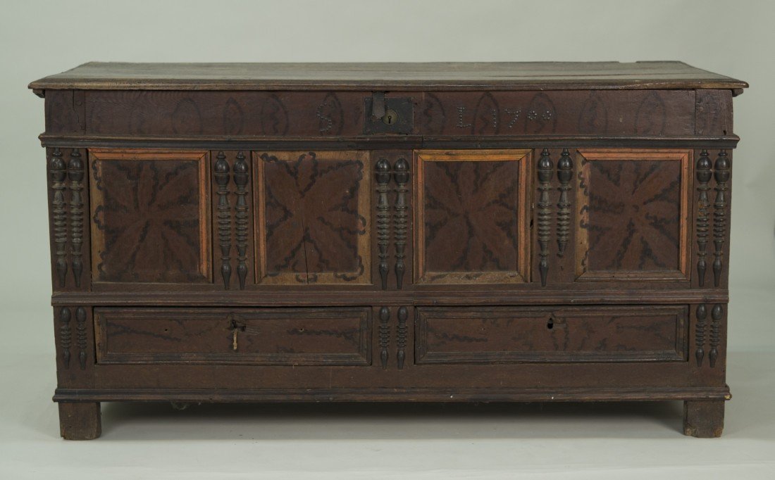ENGLISH CARVED AND PAINTED PANEL FRONT WALNUT CHEST,: ENGLISH CARVED AND PAINTED PANEL FRONT WALNUT CHEST, dated 1700; with applied split balusters and 3 drawers below; the interior of the lid with polychrome oval decoration; height: 29 in.; width: 56 in