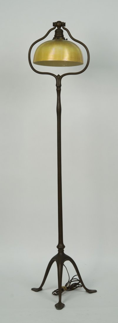TIFFANY STUDIOS PATINATED BRONZE FLOOR LAMP WITH: TIFFANY STUDIOS PATINATED BRONZE FLOOR LAMP WITH FAVRILLE SHADE; base stamped Tiffany Studios, New York; shade signed L.C.T. Favrille; height: 55 in.; diameter of shade: 10 in.