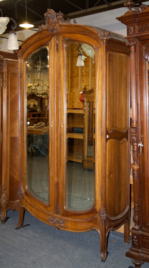 FRENCH ART NOUVEAU STYLE CARVED WALNUT ARMOIRE;: FRENCH ART NOUVEAU STYLE CARVED WALNUT TWO DOOR ARMOIRE; with carved crests; height: 104 in., width: 60 in., depth: 22 in. Other Notes: This Armoire compliments lot 580, Queen size bed. In the style o