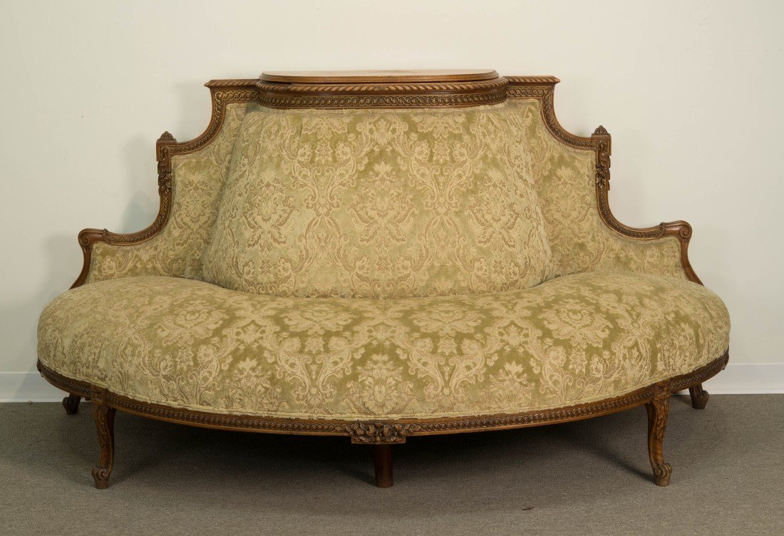 FRENCH CARVED WALNUT RECEPTION BANQUETTE;: FRENCH CARVED WALNUT DEMILUNE VELVET UPHOLSTERED RECEPTION BANQUETTE; with inset well; height: 44 in., width: 87 in., depth: 25 in.