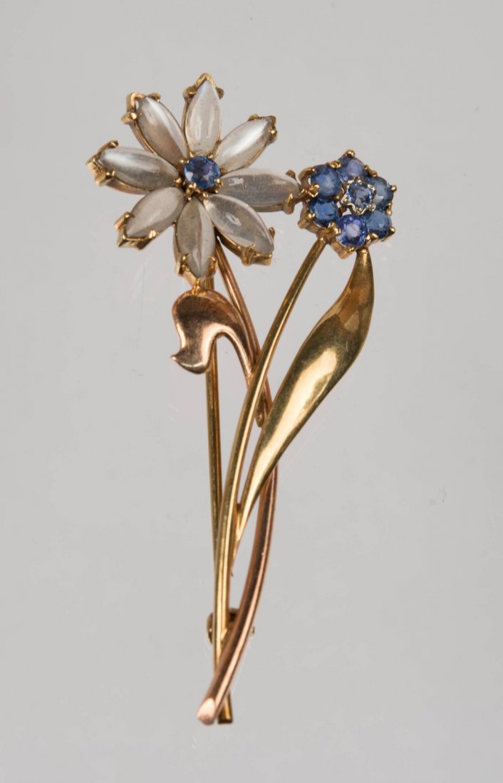 14K GOLD, MOONSTONE, AND SAPPHIRE BROOCH: 14K GOLD, MOONSTONE, AND SAPPHIRE BROOCH the bicolor gold floral-form brooch set with eight marquise-shape moonstones and eight circle-cut sapphires; 4.76 dwts.; length 2 1/4 in.