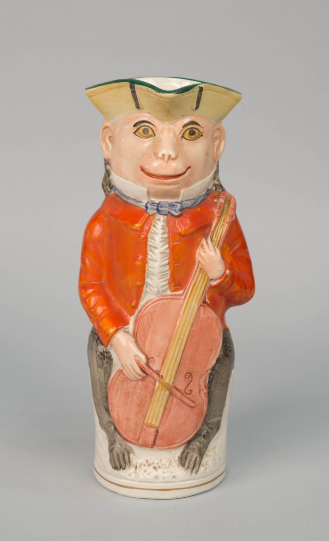 STAFFORDSHIRE MONKEY FORM TOBY JUG;: STAFFORDSHIRE MONKEY FORM TOBY JUG; depicting a monkey playing the cello; height: 11 1/4 in.