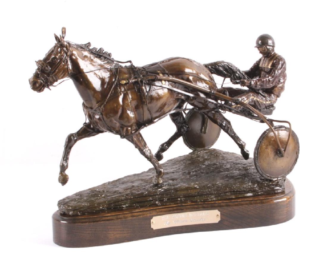 Claudia Steinley Horse Racing Bronze Sculpture: This is an original bronze sculpture by Claudia Steinley. The piece is titled "The Pacing Machine" and shows a harness racing horse and its driver seated on a sulky. The artist created this visually a