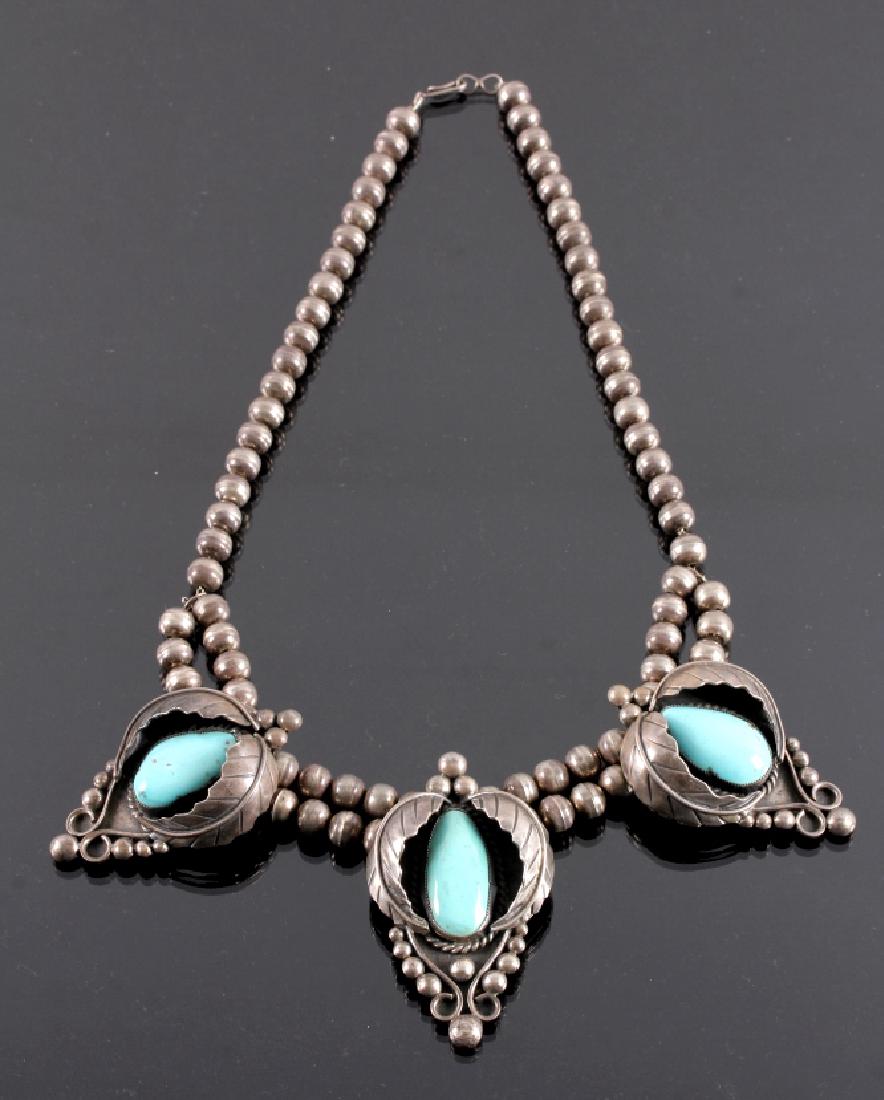 Signed Navajo Sterling Silver Squash Blossom: This is a signed Navajo Native American Indian sterling silver and turquoise shadow box squash blossom necklace. The necklace features three beautiful pendants, each one crafted in shadow box design f