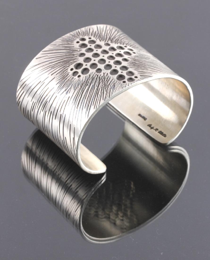 Cody Willie Heavy Sterling Silver Cross Cuff: This is a heavy sterling silver cuff made by Cody Willie. The cuff features a stunning hammered cross with emanating rays that provides a visually striking presence. The back of the cuff is signed "Co