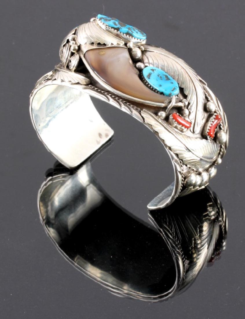 Navajo Sterling Silver Turquoise Bear Claw Cuff: This is a Navajo Native American Indian turquoise, coral and bear claw cuff made by Elaine Sam. The cuff is made from solid sterling silver with stamped and hand tooled accents. The silver is set with