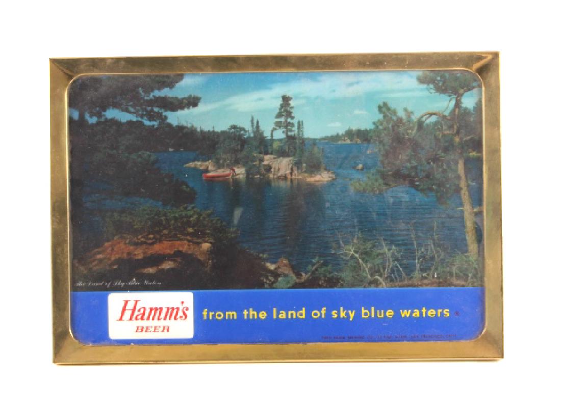 Hamm's Beer Lighted Advertising Sign: This is a Hamm's Beer lighted advertising sign. The sign shows a mountain lake scene and reads "Hamm's Beer / From the Land of Sky Blue Waters". The sign is trimmed out in a brass frame. The Hamm's li