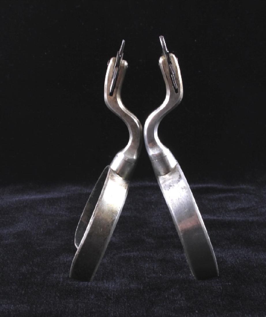 Antique Heel Screw Cowboy Western Spurs: This is a pair of antique heel screw cowboy Western spurs. The spurs are marked "Norma" and show a raised shank design with horizontal rowels. The spurs are in good condition. Each one measures 2.25"