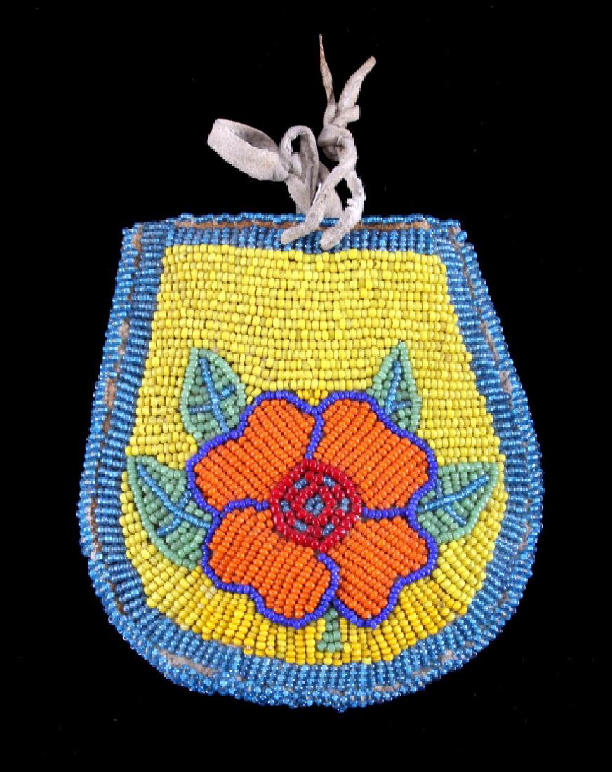 Crow Native American Beaded Pouch: This is a Crow Native American Indian beaded pouch from the early to mid 1900's. The pouch is made from tanned hide and shows a beautifully beaded floral design on the front. the beadwork is done in C