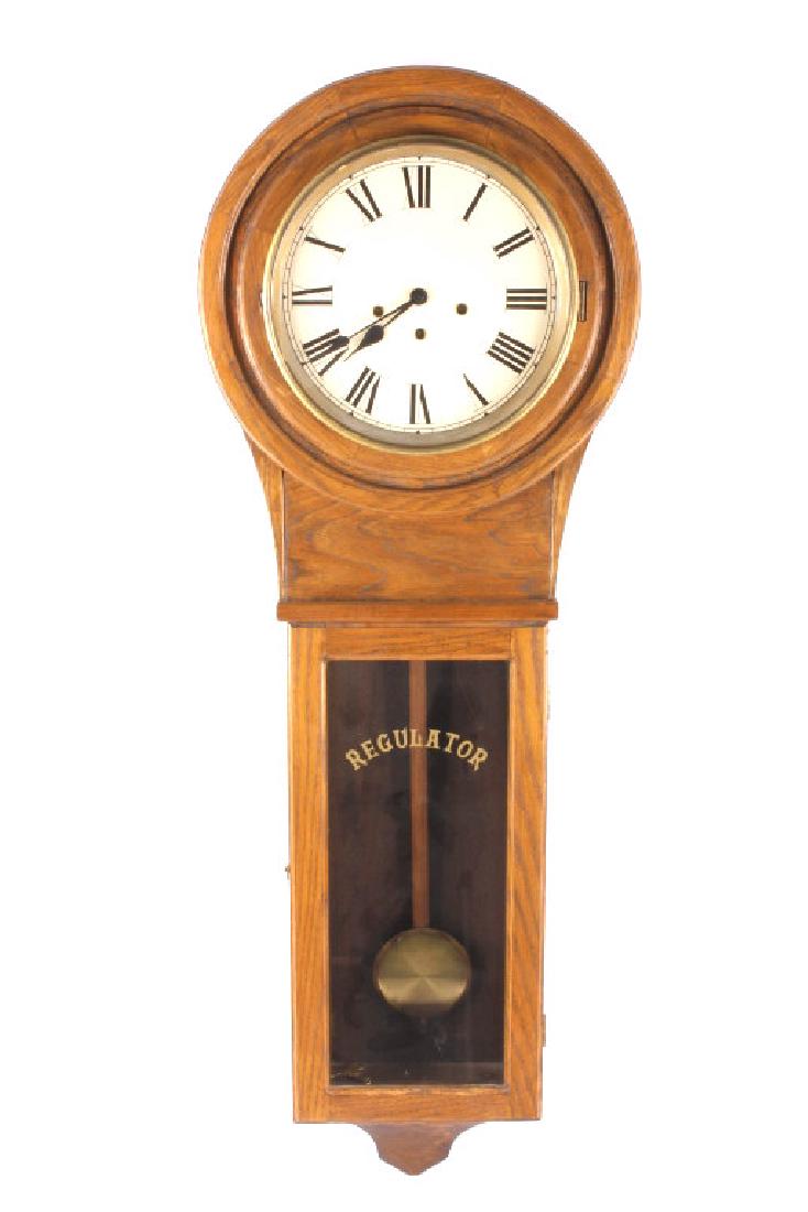 Early American Oak Regulator Wall Clock LARGE: This is an early antique regulator wall clock. The clock features a solid American oak case with a mechanical chiming movement. The piece shows a beautiful round top that holds the clock face. The gla