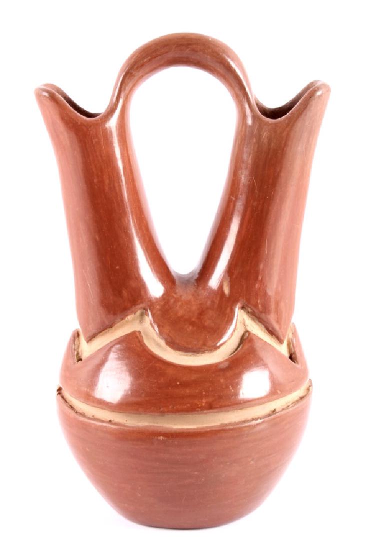 San Ildefonso Pueblo Red Wedding Vase: This is a San Ildefonso pueblo red wedding vase. The vase shows the traditional design and has been hand painted. The wedding vase is in good condition. It measures 4.25" wide and is 7" tall.