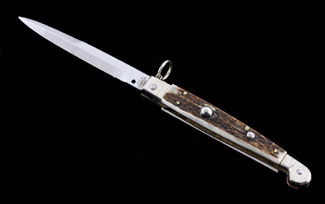 Campolin Italian Stag Horn Switchblade Knife: This is an original Campolin Italian stiletto switchblade knife. The knife features stag horn grips with a push button to release the blade and a ring pull release to close the blade. The blade is mar