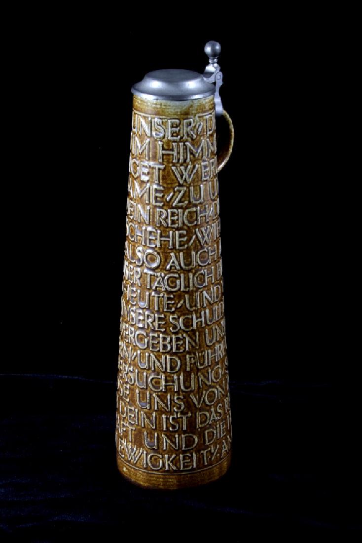 German Hohe Goebel Merkelbach Ceramic Stein: Offered for sale is a German Hohe Goebel Merkelbach Ceramic Stein. The stein features a tall tapered design, metal lid, small handle, and quality construction. The stein is in good condition with litt
