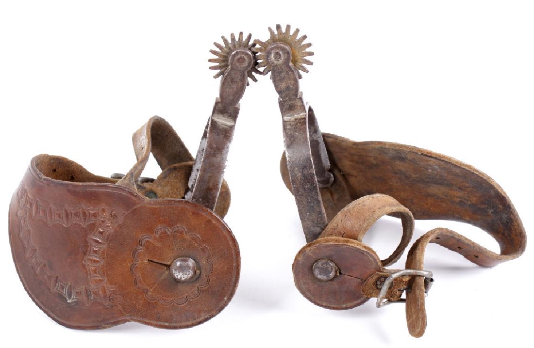 August Buermann Forged Steel Spurs 1880-1915: For sale in this lot is a pair of August Buermann forged steel dressage spurs. The spurs have an impressive tooled leather half mount strap, with ornate hand tooling decorations. The spurs are both ma