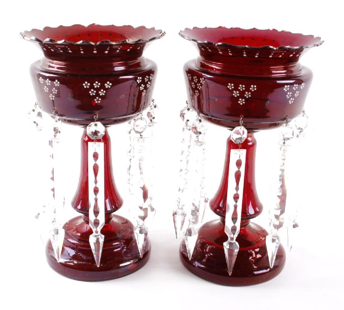 Vicrtorian Cranberry Lustre Vases Circa 1870-90: Offered to you in this lot is a pair of two antique Lustre vases, crafted of glass, and finished with a gorgeous cranberry hue. The lustre's are adorned with six enamel flowers above each intricate cr