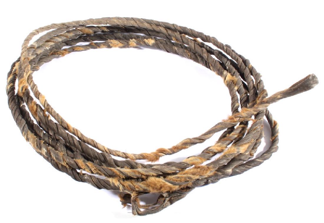 Unusual Rawhide Braided Lariat: Offered for bidding in this lot is an antique rawhide lariat. The unusual piece is constructed of tanned hide, and still displays fur lining. The lariat is in good condition overall. The rope measures
