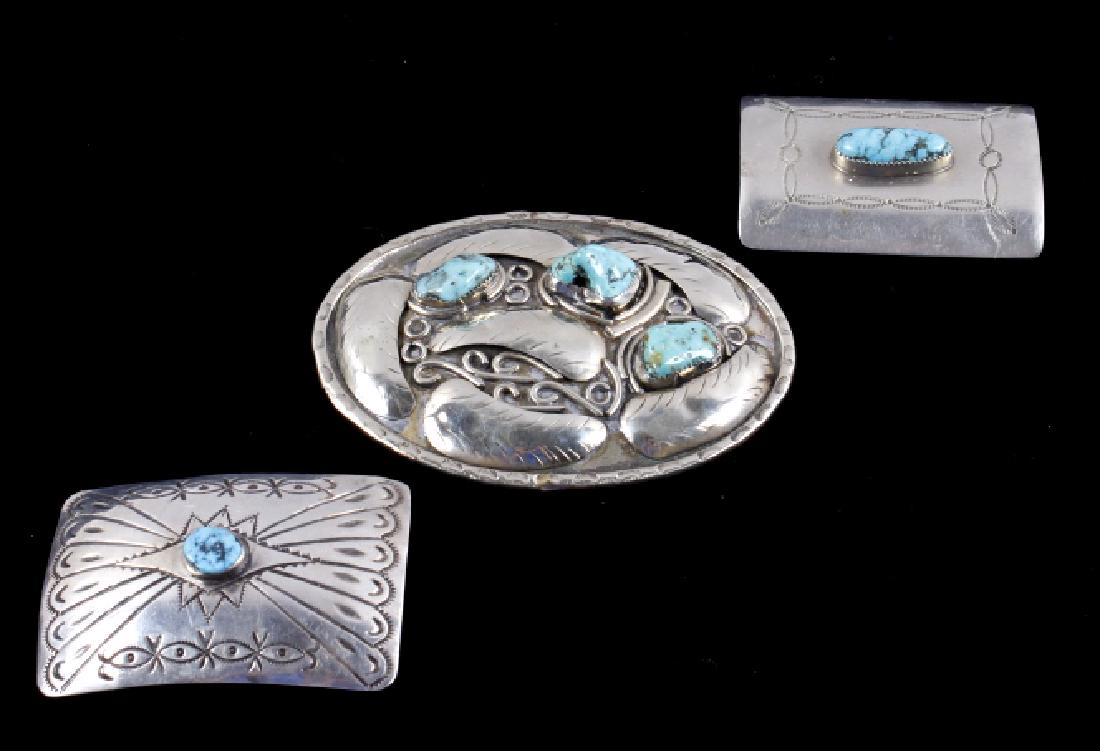 Navajo Turquoise & Silver Belt Buckles & Brooch: Included in this lot for bidding is a set of two silver colored, and turquoise belt buckles, and one buckle that has been converted to be used as a brooch pin. One of the belt buckles has a central nu