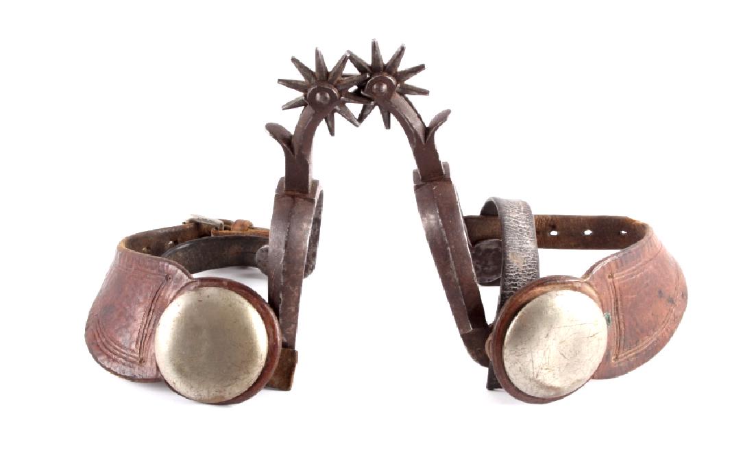 Antique Buermann Star Marked Spurs: This is a pair of antique Buermann spurs with leather straps. The spurs show a hand forged construction with a drop shank. They are marked with a 5-point star and "Pat'd" under one button and the othe