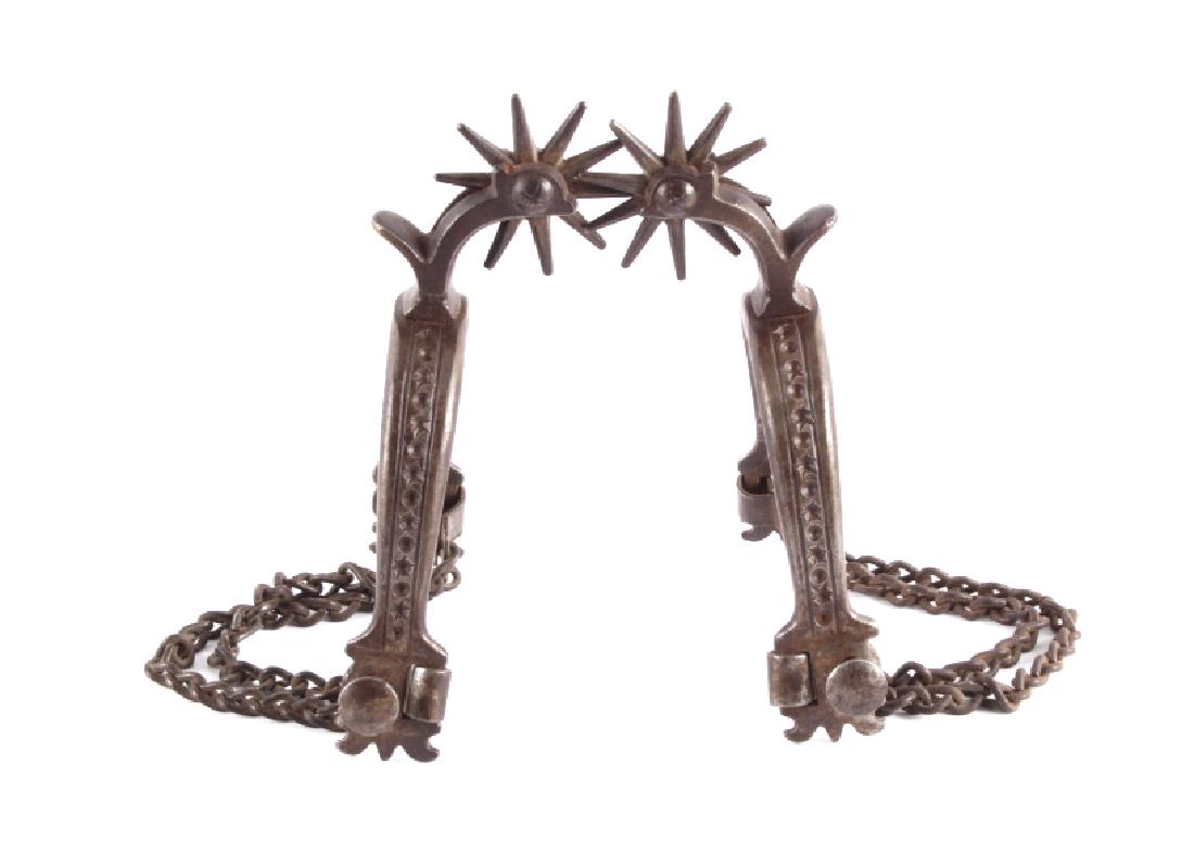 Antique Buermann Drop Shank Spurs: This is a pair of antique Buermann drop shank spurs. The spurs show the iconic star and dot pattern on the heel band. The drop shanks hold the original 10-point rowels. The spurs have double heel chai