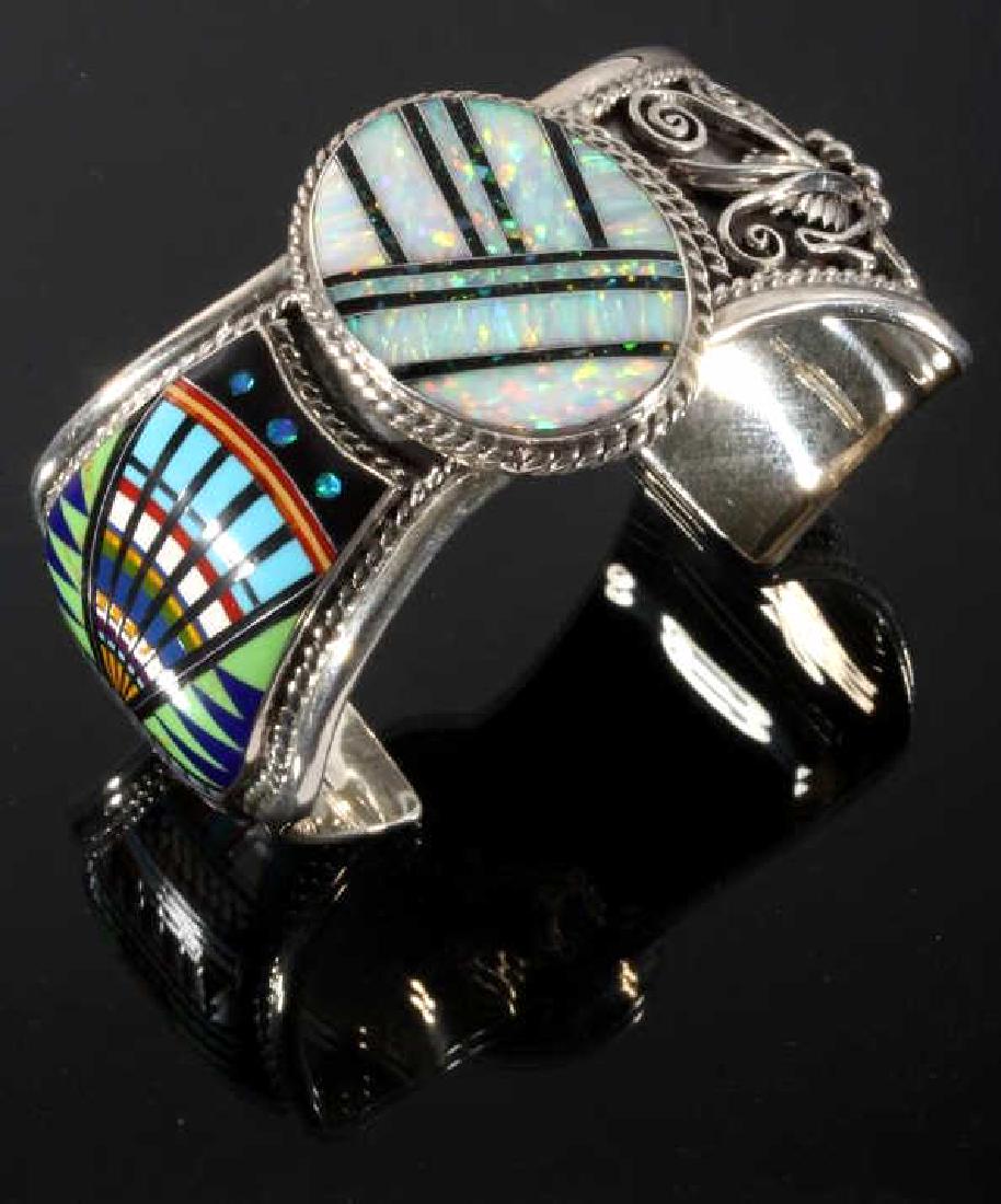 Signed Navajo Multistone Micro Mosaic Silver Cuff: This lot gives you the opportunity to bid on a signed Navajo Native American Indian multi-stone micro mosaic cuff. The piece is adorned with a central white and black opal face in the center, flanked 